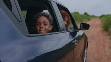 Pan past mother and her child seated in vehicle 