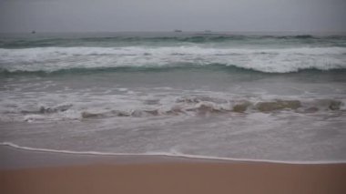 Waves seen at coast with boats in distance