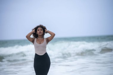 Arka planda dalgalar olan bir kadının yakın plan çekimi.