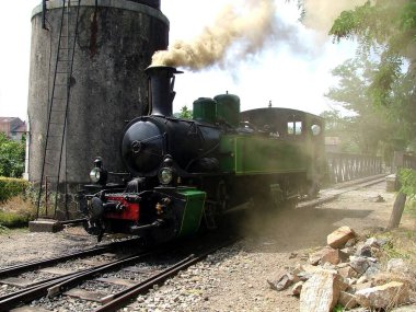 Kazan dairesine yakıt ikmali yapmak için su kulesinin yanındaki raylarda lokomotif duruyor.