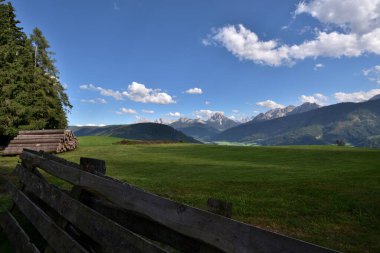 Tesido kasabasının yukarısındaki dağlarda tarım için kullanılan geniş çayırlar Dolomite tepelerinin harika manzarasının tadını çıkarırlar.