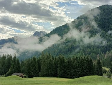 Braies Vadisi 'ndeki ormanların üzerinde sabah buharı. Serla Dağı manzarada tek başına