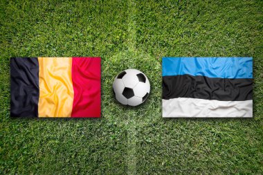 Yeşil futbol sahası Belçika vs Estonya bayrakları