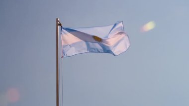 Mavi gökyüzünde bayrak direğinde Arjantin bayrağı