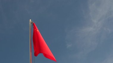 Mavi gökyüzünün önündeki bayrak direğinde Çin 'in tekstil bayrağı