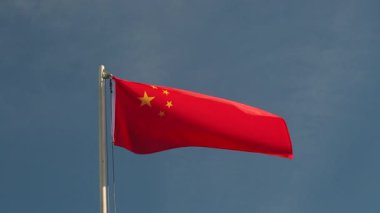 Mavi gökyüzünün önündeki bayrak direğinde Çin 'in tekstil bayrağı