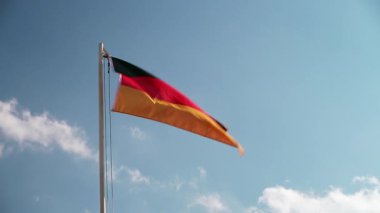 Mavi gökyüzünün önündeki bayrak direğinde Almanya, Avrupa tekstil bayrağı 