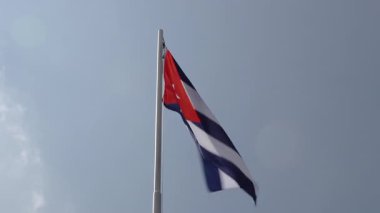 Bir bayrak direğine mavi gökyüzü önünde Küba'nın ulusal bayrağını