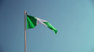 Mavi gökyüzünün önündeki bayrak direğinde Nijerya 'nın tekstil bayrağı