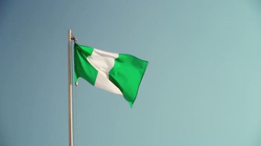 Mavi gökyüzünün önündeki bayrak direğinde Nijerya 'nın tekstil bayrağı