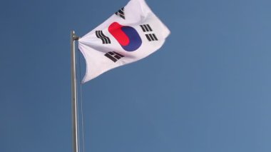 Mavi gökyüzünün önündeki bayrak direğine Güney Kore 'nin ulusal bayrağını çekin.