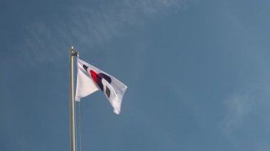 Mavi gökyüzünün önündeki bayrak direğine Güney Kore bayrağı istiyorum.