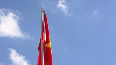 Mavi gökyüzünün önündeki bayrak direğine Vietnam bayrağı çekin.