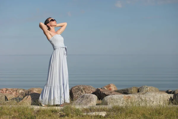 若い細い女性が服を着て海にポーズをとって — ストック写真
