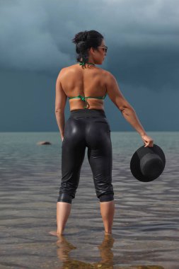 Deniz ve bulutların arkasında genç bir kadın