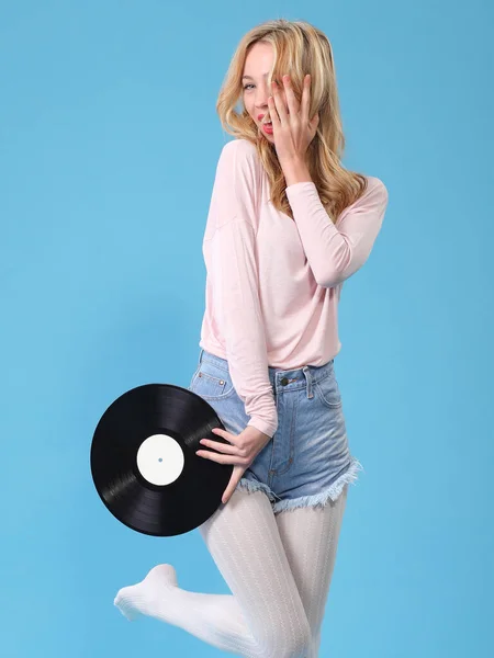 young woman with vinyl record on blue background