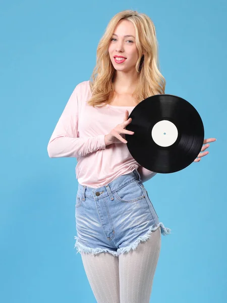 young woman with vinyl record on blue background