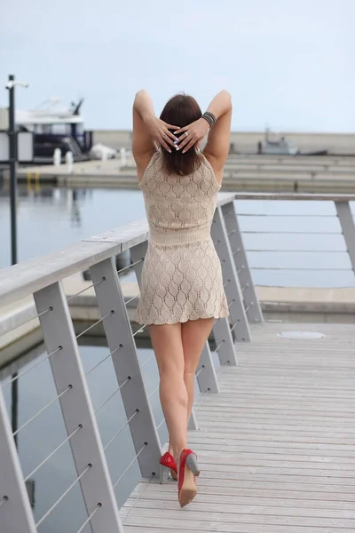 ヨットの近くの細いドレスを着た若い女性が — ストック写真