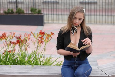 Elinde kitapla genç bir kız.