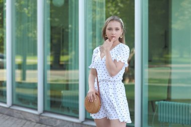 Dışarıda poz veren elbiseli güzel bir kadın.