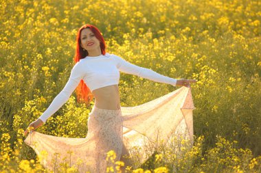 Kolza tohumu tarlasında genç güzel bir kadın.