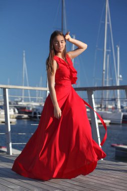 Kırmızı, uzun moda elbiseli genç Asyalı.