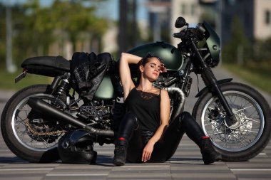 Siyah motosikletli çekici genç bir kadının portresi.