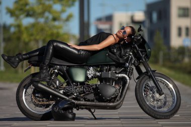 Siyah motosikletli çekici genç bir kadının portresi.