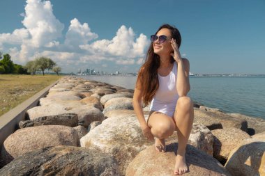 young beautiful woman in a white swimsuit against the sky