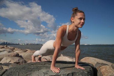 young beauty athletic woman practicing yoga on the beach
