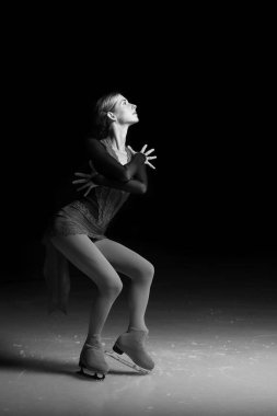 Artistik patinajcı kadın dans edip buz pateni yapıyor.