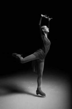 Artistik patinajcı kadın dans edip buz pateni yapıyor.