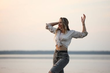 Deniz kenarında poz veren güzel bir kadın.