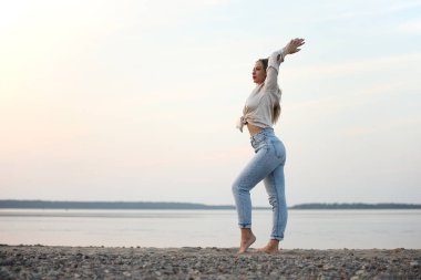 Deniz kenarında poz veren güzel bir kadın.