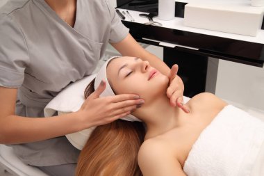 Güzel kadına bir spa salonu yüz masajı.