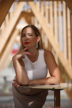 Beyaz bluzlu ve uzun etekli genç kadın.