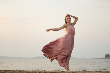 Genç, zayıf, güzel, ince vücutlu, kırmızı elbiseli bir kadın.