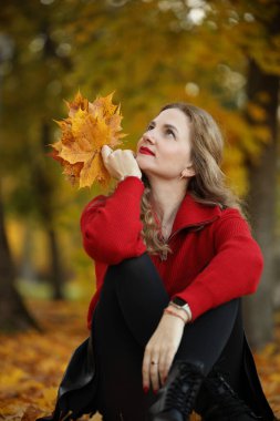 Kırmızı kazaklı genç beyaz kadının sonbahar portresi