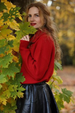 Kırmızı kazaklı genç beyaz kadının sonbahar portresi