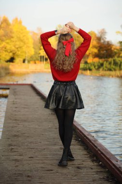 Kırmızı kazaklı genç beyaz kadının sonbahar portresi