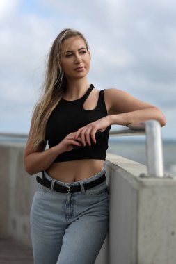 Siyah bluzlu ve açık mavi kotlu genç kadın.