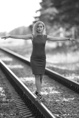 Demiryolunda giyinmiş genç bir kadın.