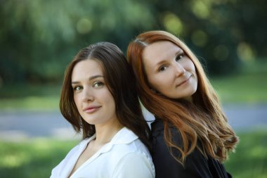 Yumuşak ışıkta arka arkaya poz veren iki kadın