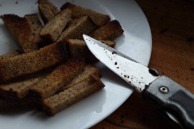 Kapalı mekanda dilimlenmiş ekmek ve metal bıçağın yakın çekimi..