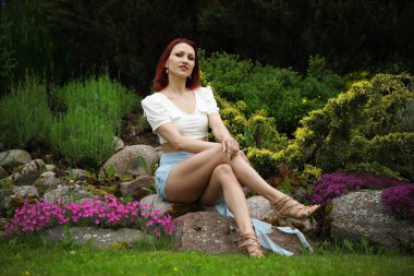 Güzel bir kadın zarif poz veriyor canlı bahar çiçekleri arasında