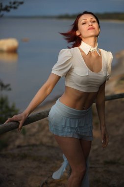 Mutlu genç kadın deniz kenarında doğanın tadını çıkarıyor.