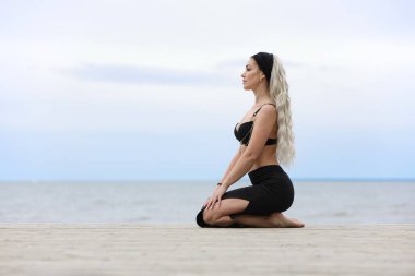 Kadınlar yazın okyanus kenarında dinamik dans pozu verirler.