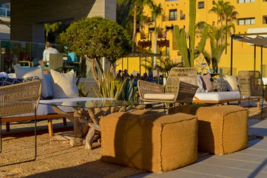 Boho chic armchairs for an outdoor event on the beach, with a cactus garden.