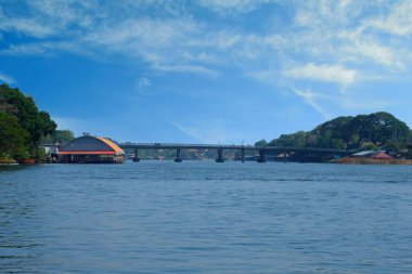 Mavi gökyüzünün altında, nehrin üzerinde uzun bir köprü