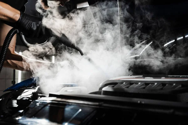 stock image Process of steam cleaning car engine from dust and dirt. Steaming washing of motor of auto in detailing auto service